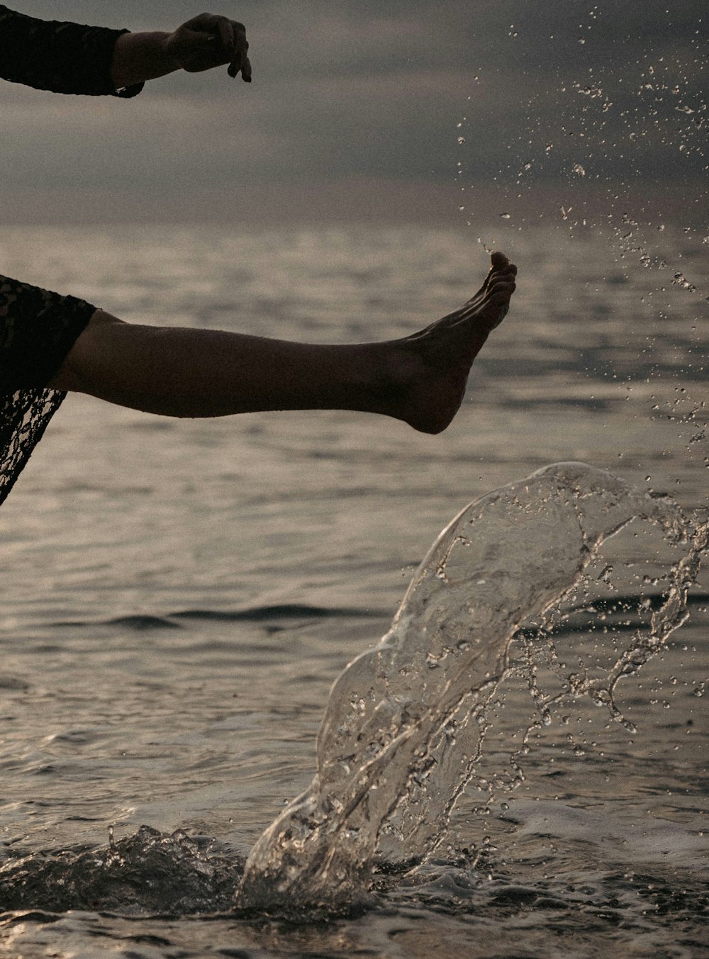 a person jumping into the water with a frisbee