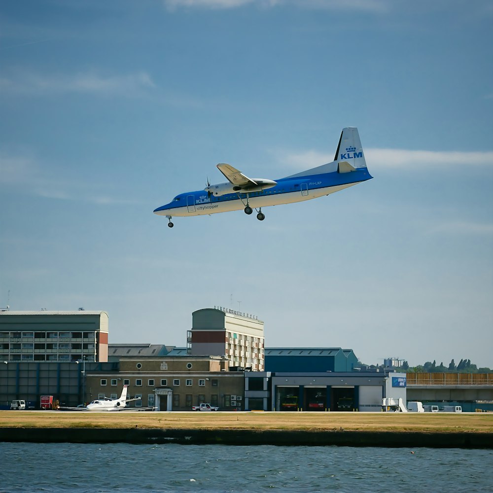 Un aereo blu e bianco che sorvola uno specchio d'acqua