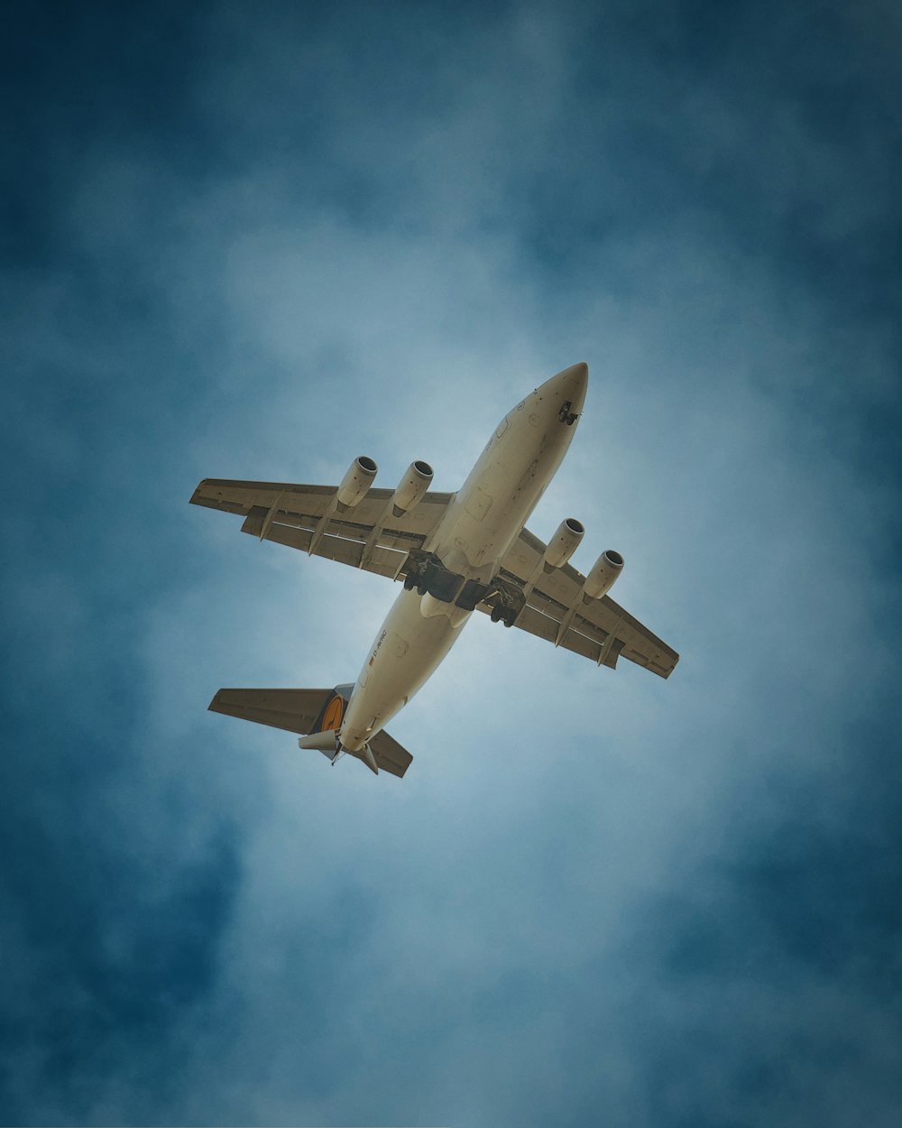 a large jetliner flying through a cloudy blue sky