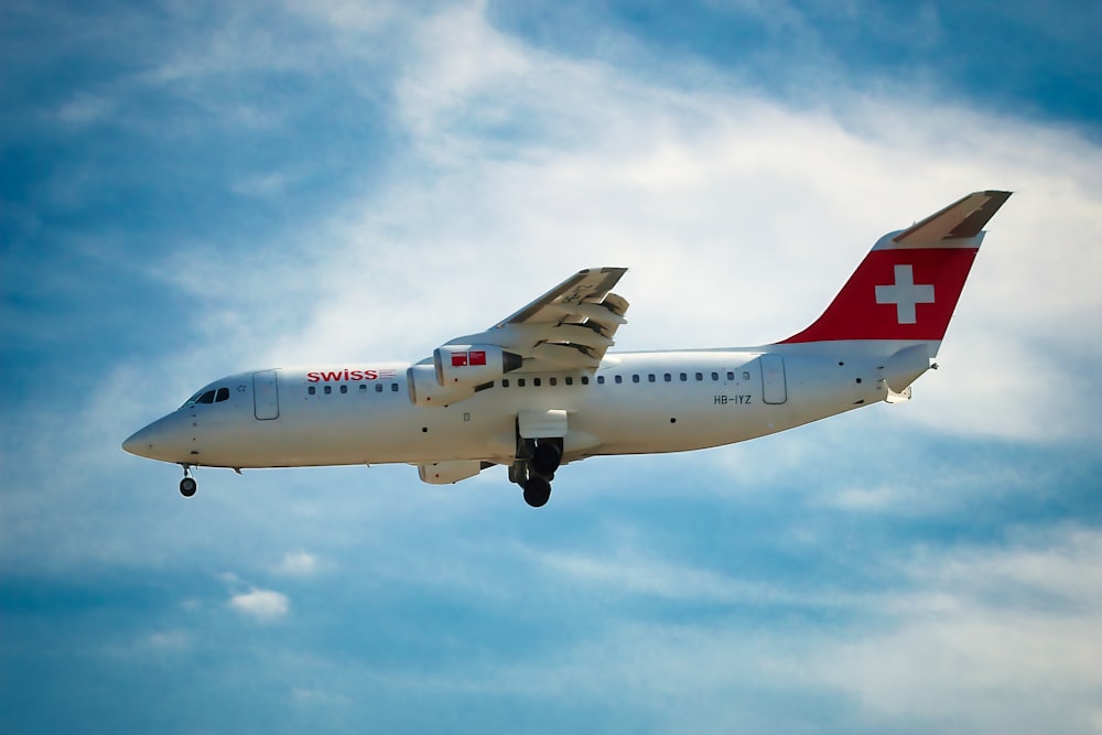 a white and red airplane flying in the sky