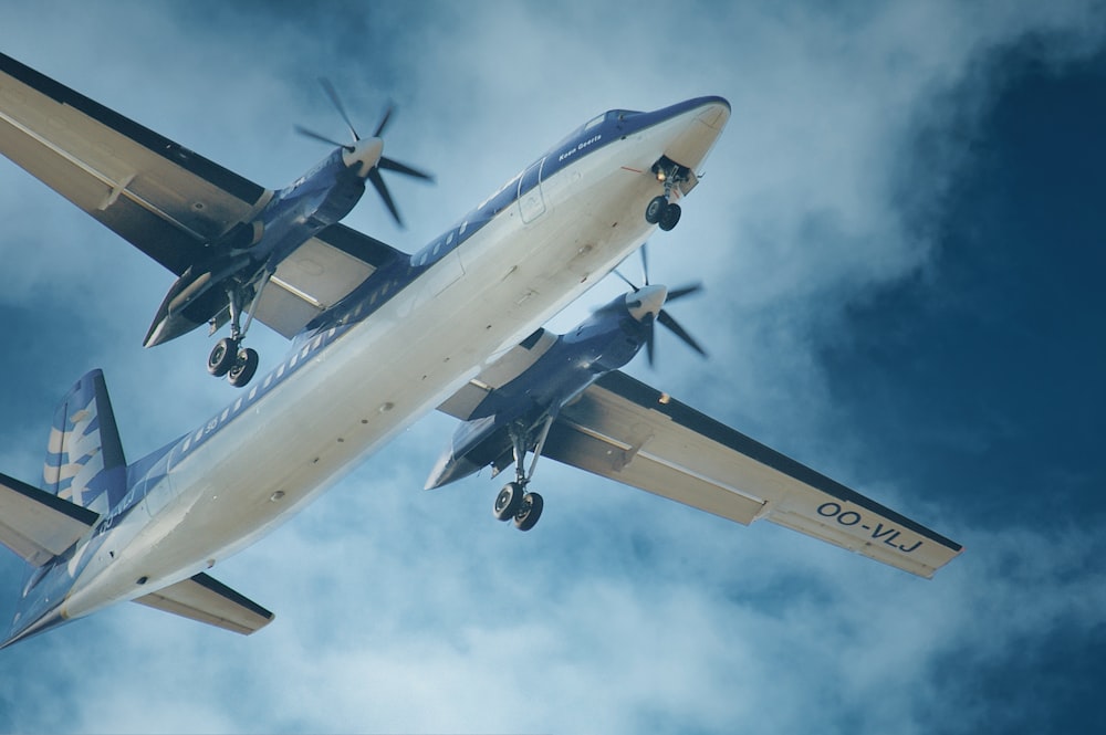 a large airplane flying through a cloudy blue sky