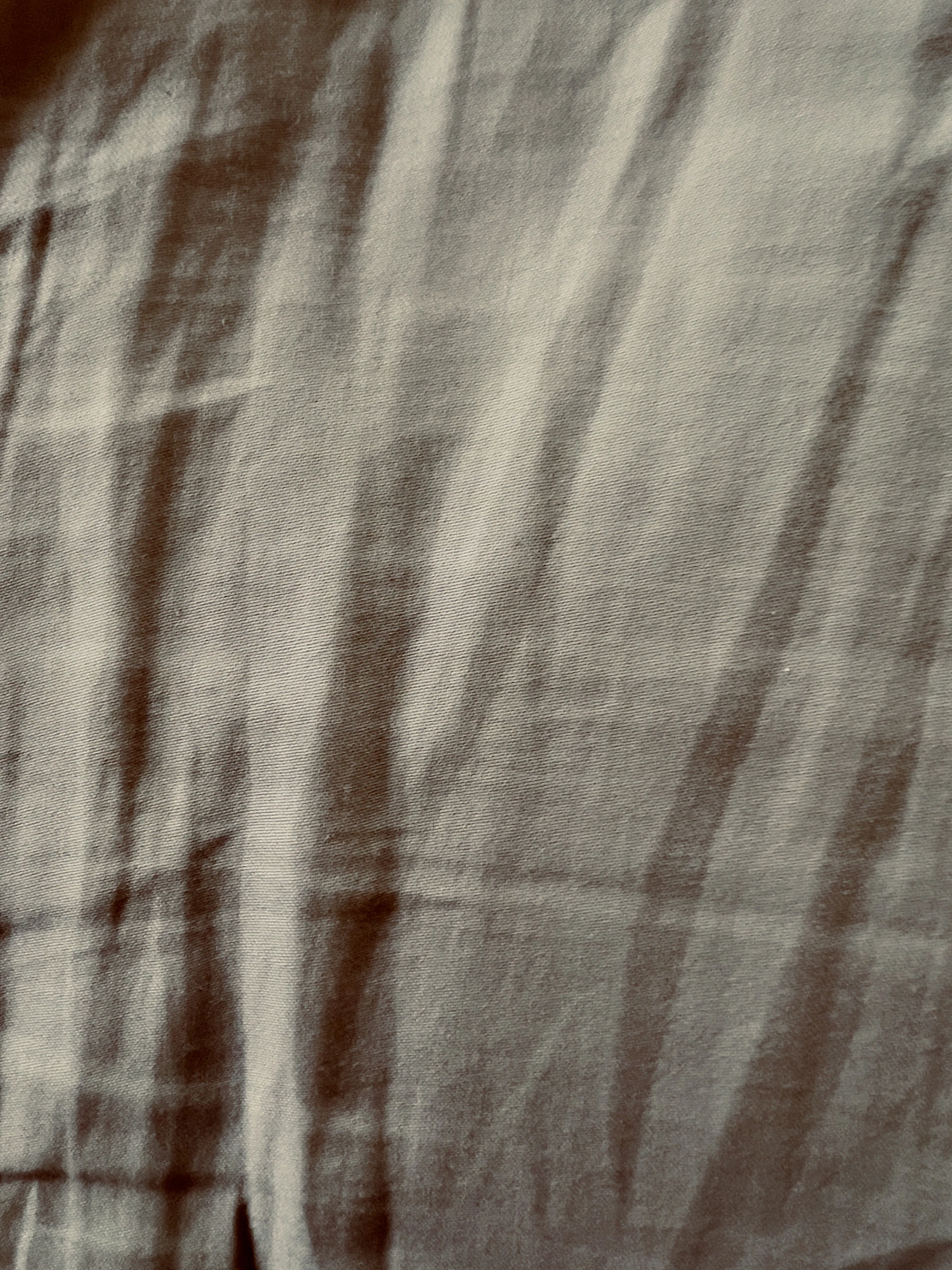 Beige silk draped in soft folds, catching daylight