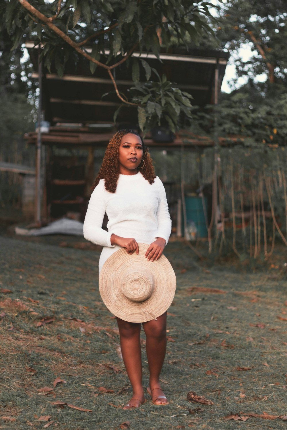 a woman standing in a field with a hat on her head