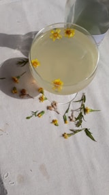 a glass filled with a drink sitting on top of a table