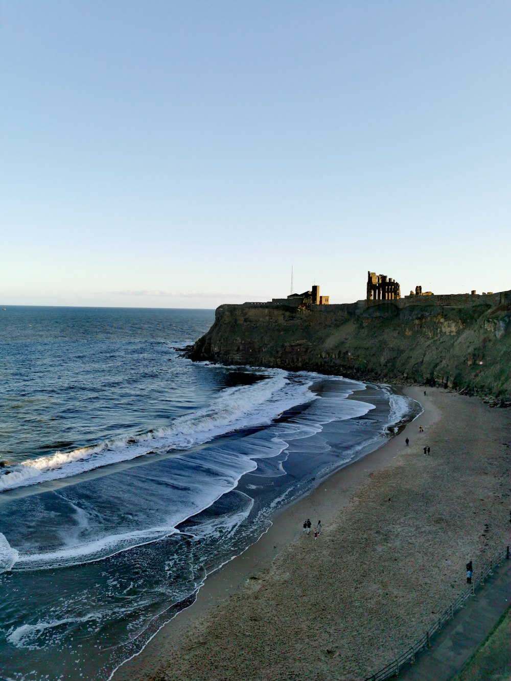 a view of a beach with a cliff in the background