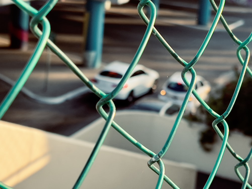 a view of a parking lot through a chain link fence