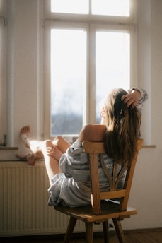 a woman sitting in a chair reading a book