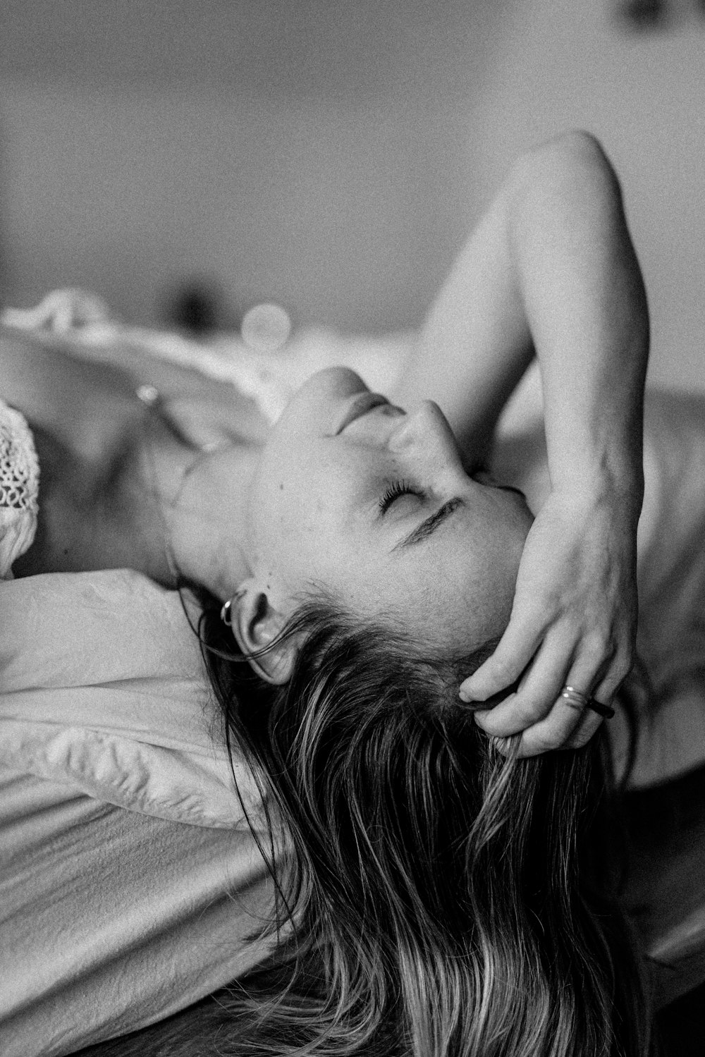 a black and white photo of a woman laying on a bed