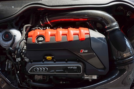 a close up of a car engine with an orange engine cover