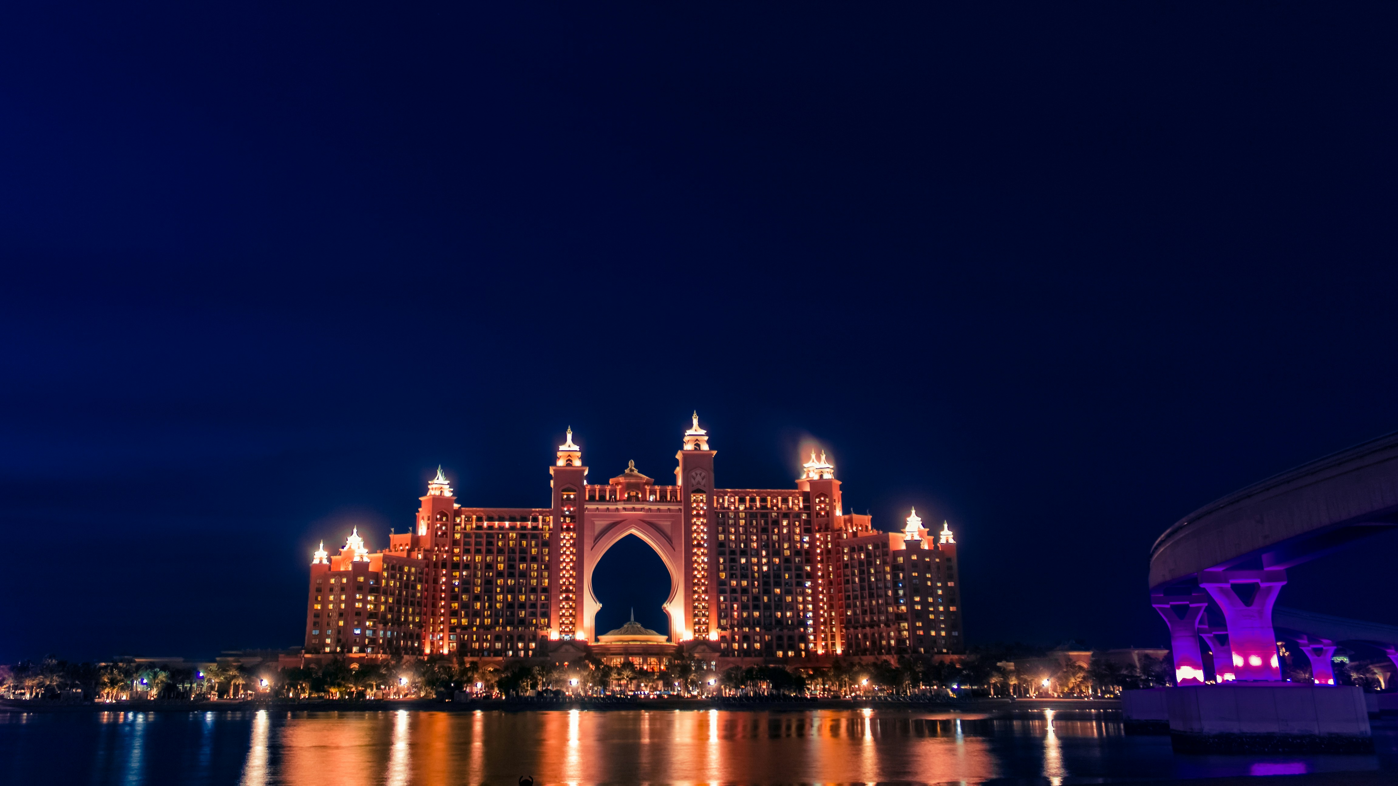 a large building lit up at night over a body of water