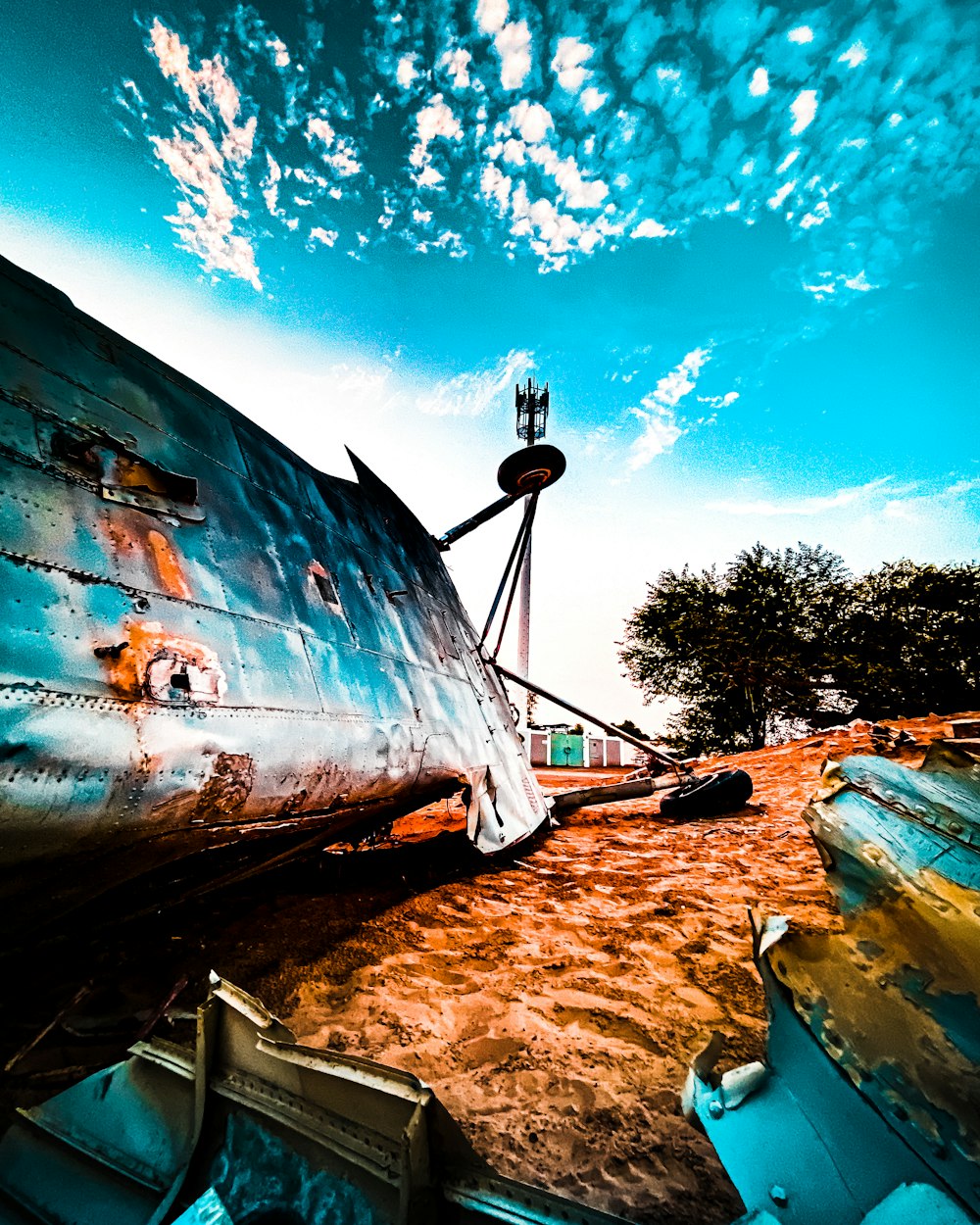 a rusted airplane sitting on top of a dirt field