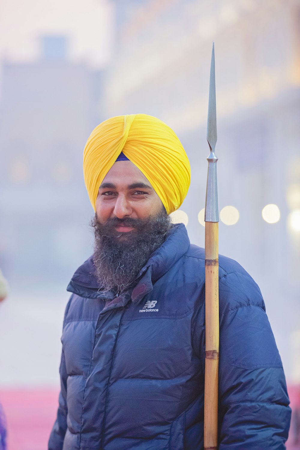 a man with a yellow turban holding a stick