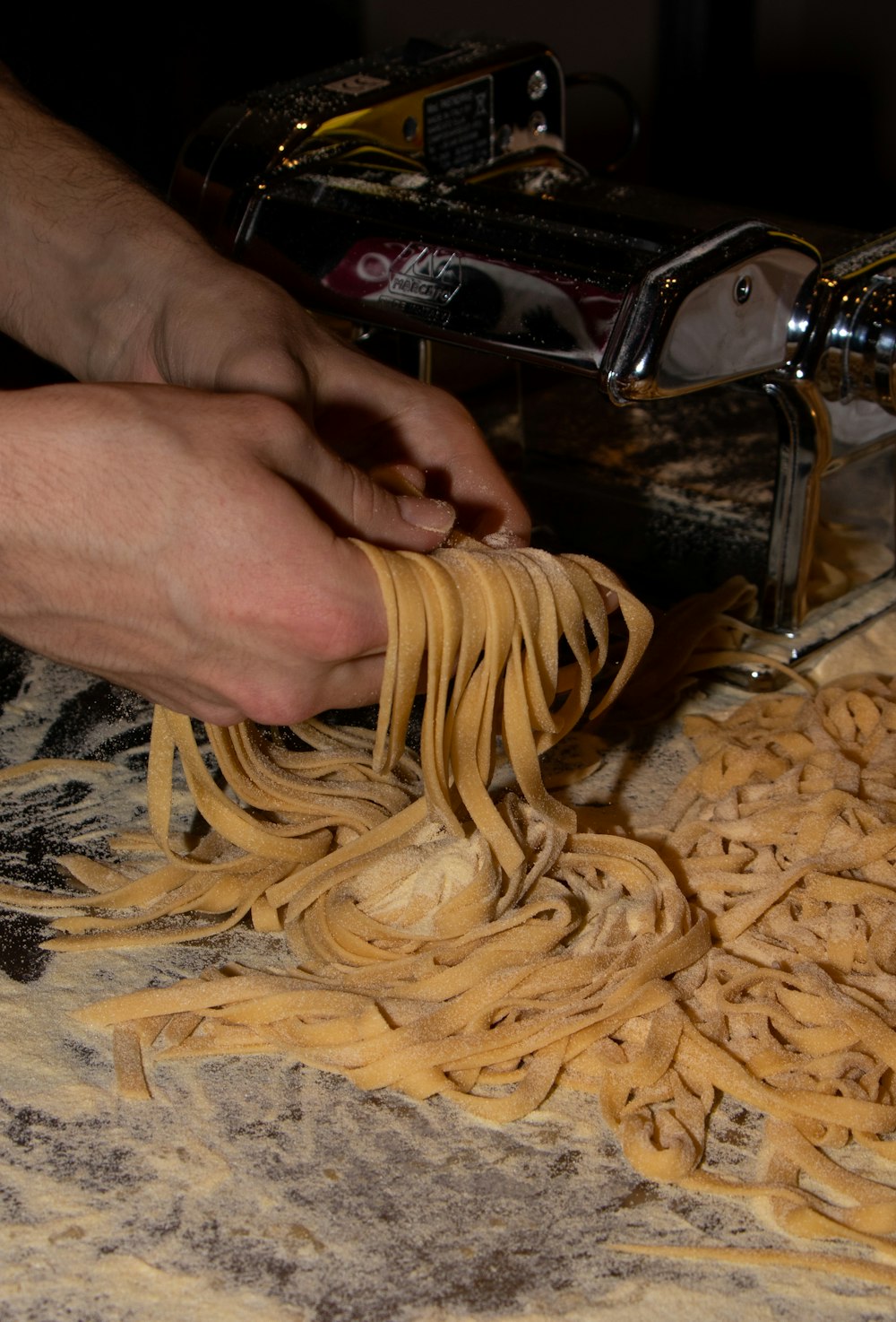 a person is using a pasta machine to make pasta