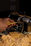 Close-up of handmade pasta being carefully prepared in a warm kitchen.