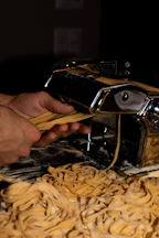 Close-up of handmade pasta being carefully prepared in a warm kitchen.