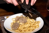 a plate of pasta with meatballs and a knife