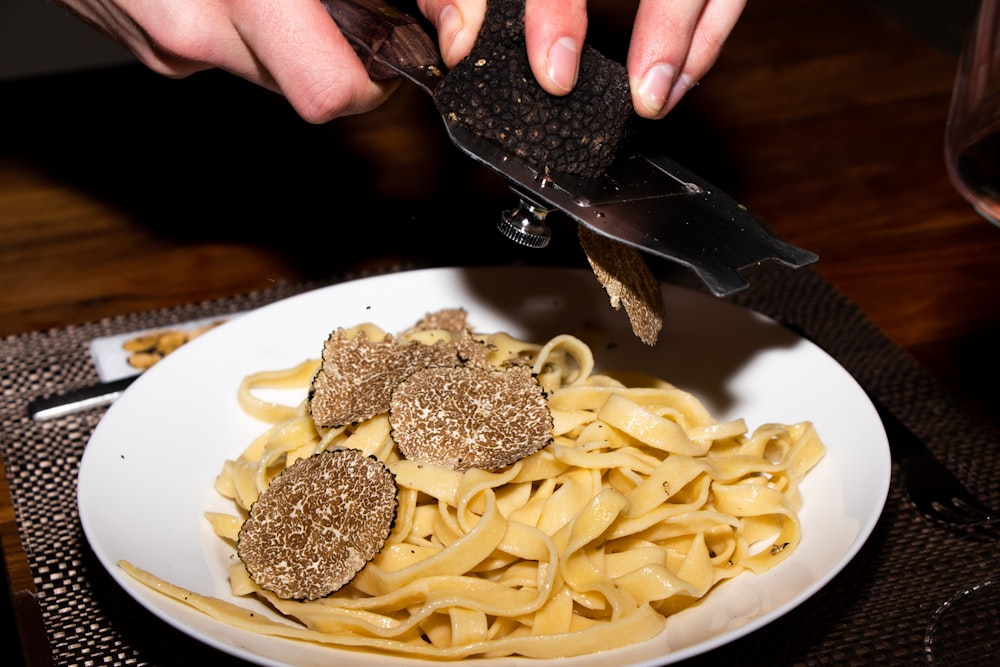 ein Teller Nudeln mit Fleischbällchen und einem Messer