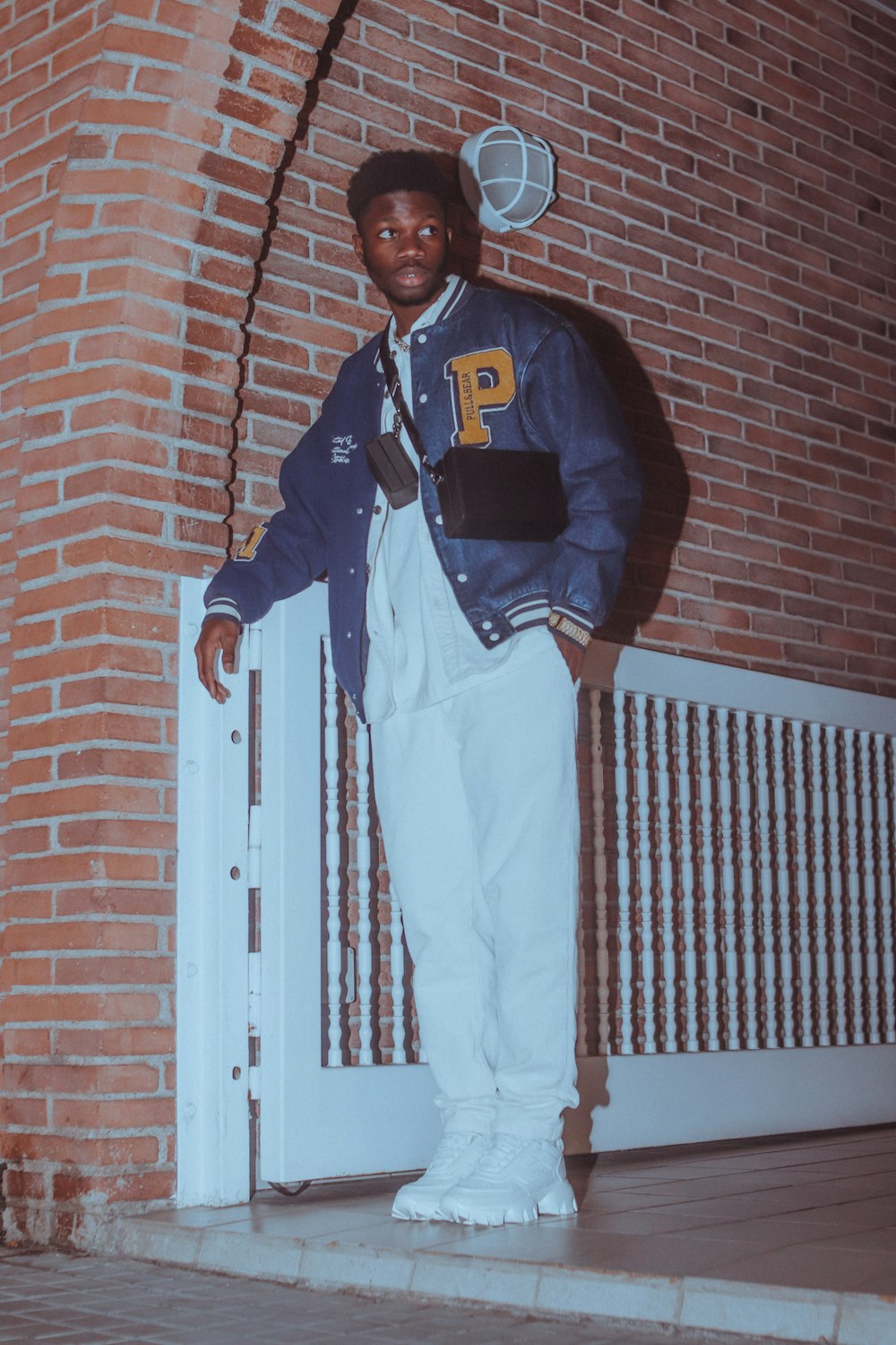 a man standing in front of a brick building