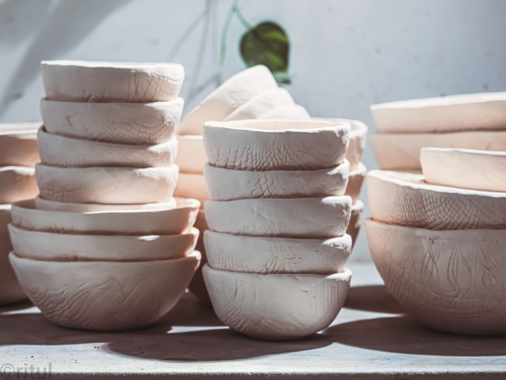 a stack of white bowls sitting on top of a table