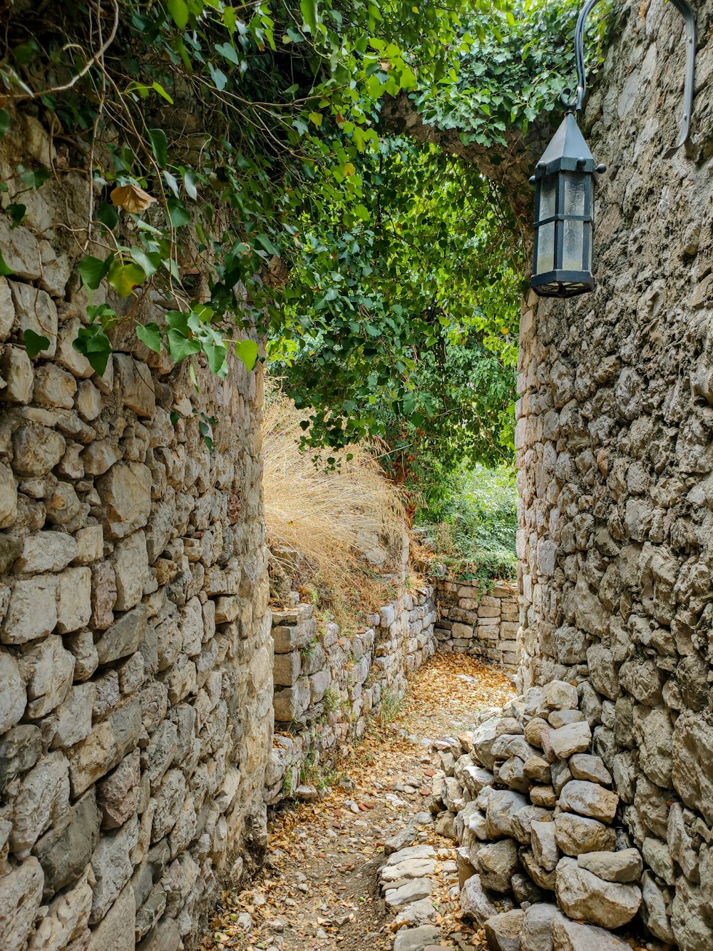 eine Steinmauer mit einer Laterne, die daran hängt