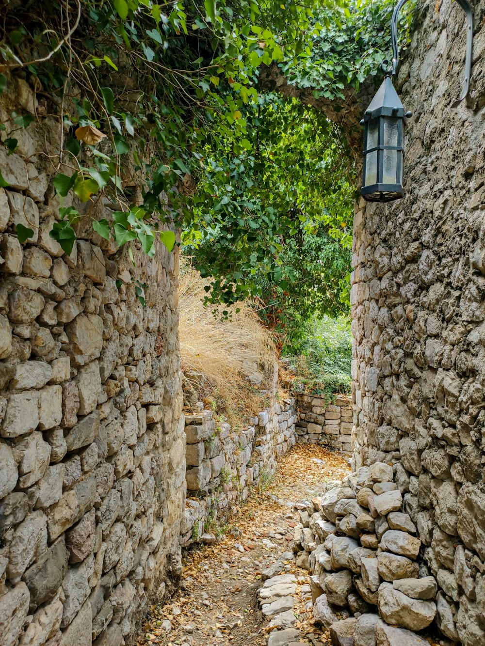 un mur de pierre avec une lanterne suspendue