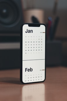 a calendar phone case sitting on top of a wooden table