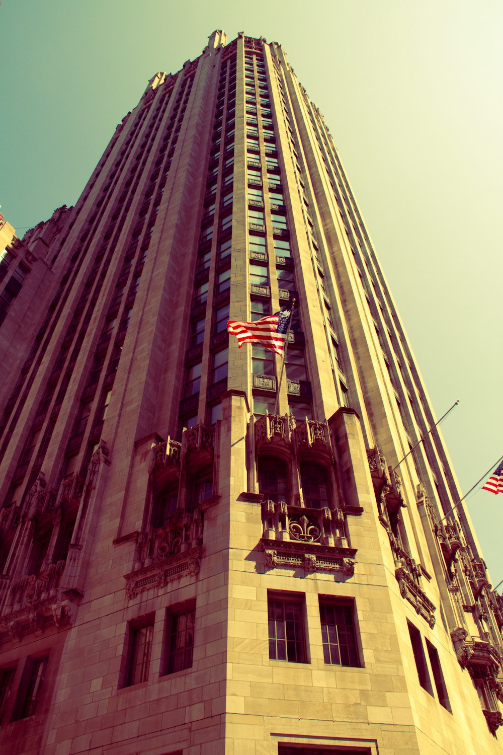 a tall building with american flags flying in front of it