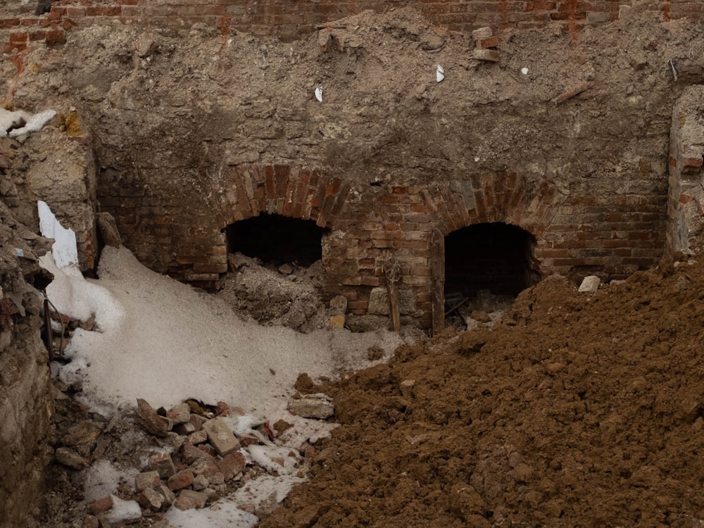 a pile of dirt next to a brick wall