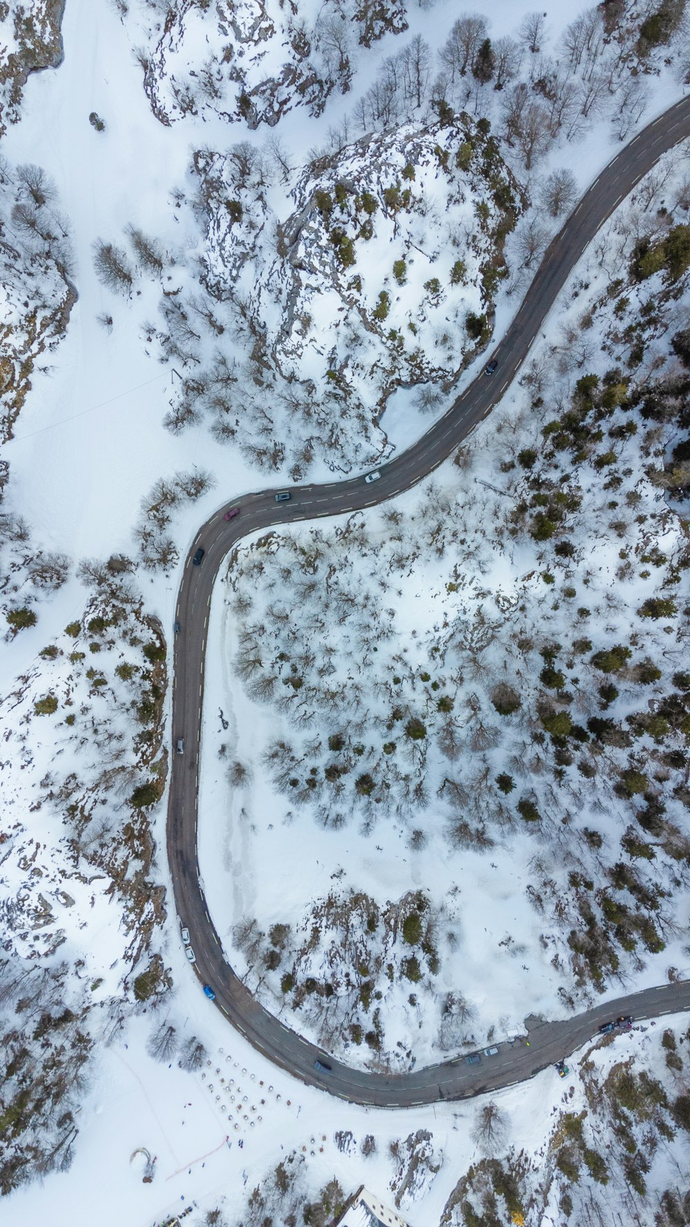 an aerial view of a winding road in the snow