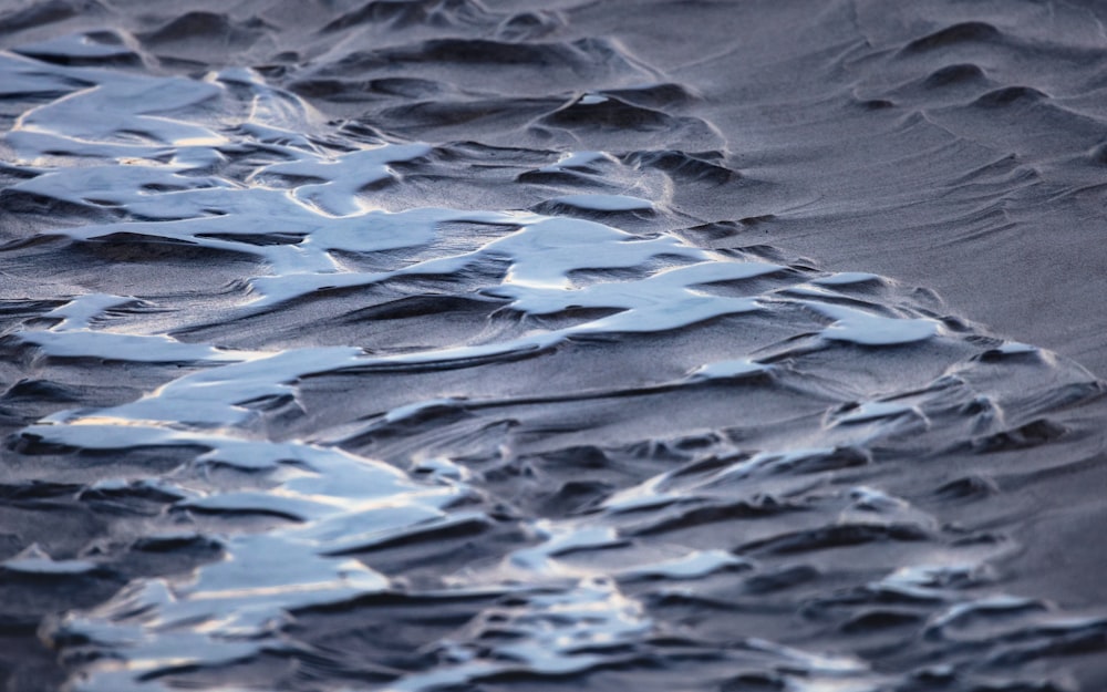 a close up of the sand and water on a beach