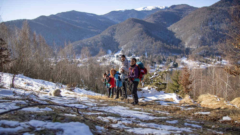 a group of people standing on top of a snow covered slope