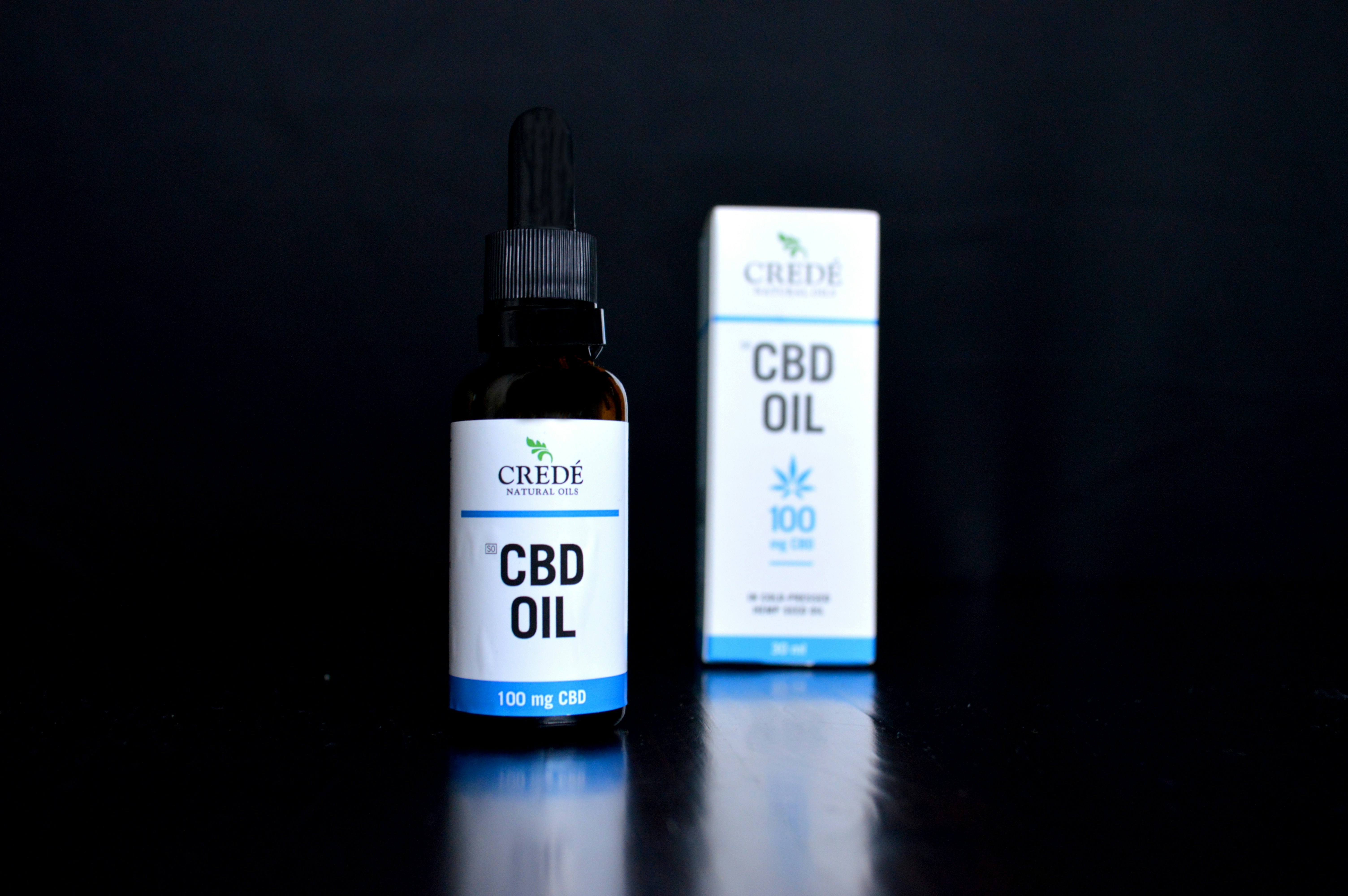 a bottle of cbd oil next to a box of cbd oil