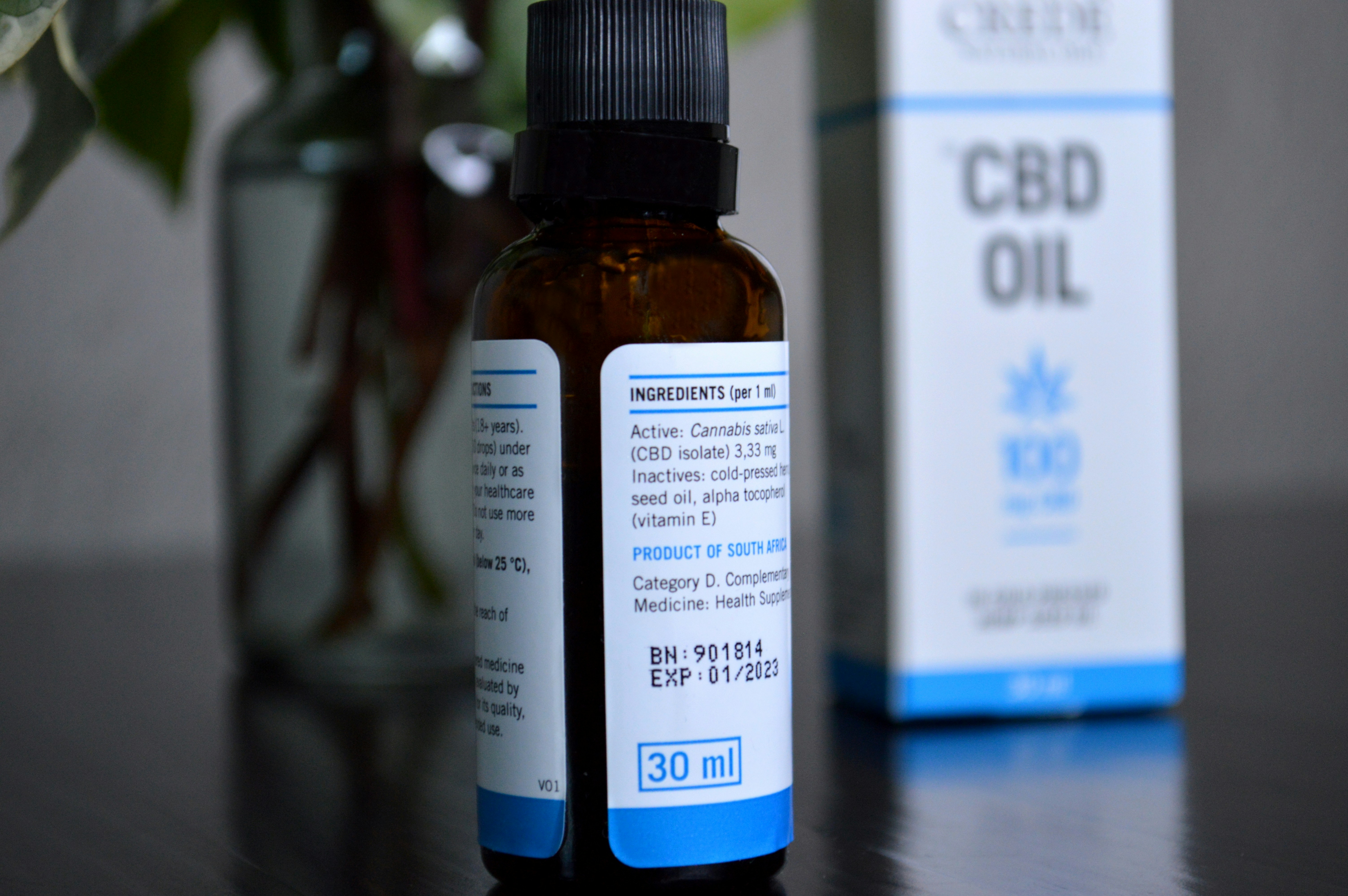 Eine Flasche CBD-Öl neben einer Schachtel CBD-Öl