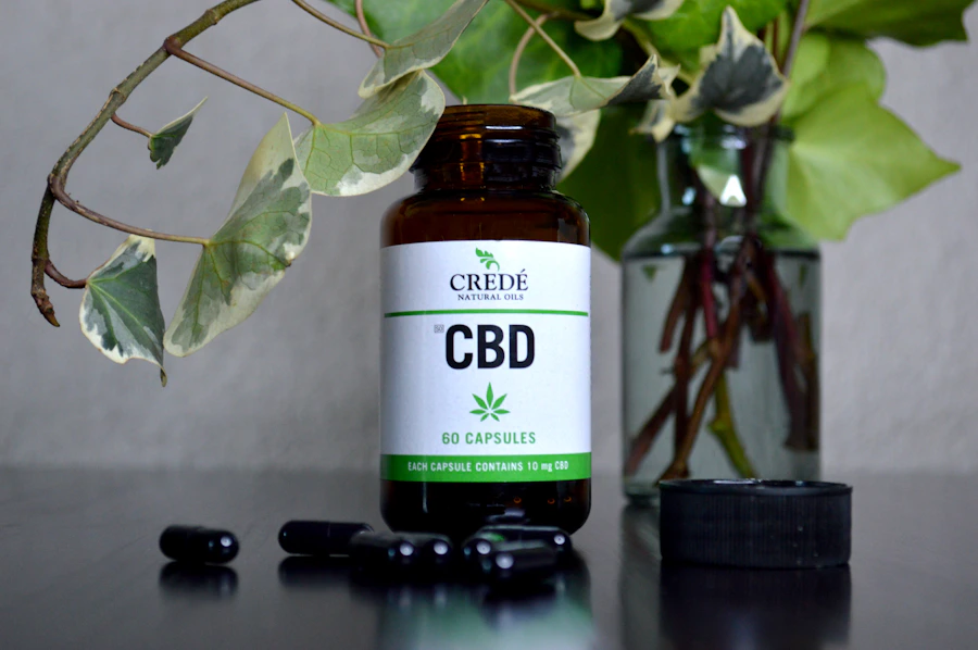 Bottle of CBD capsules beside a hemp leaf