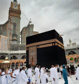 Pilgrims walking peacefully near the Kaaba during sunset with warm light.