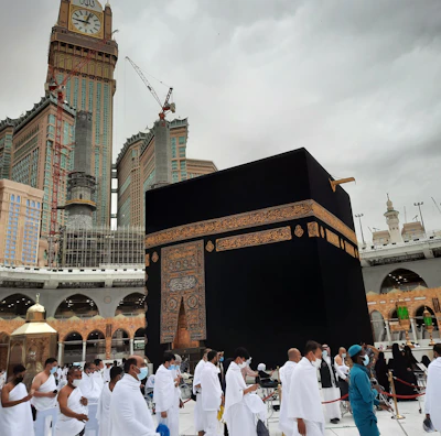 Pilgrims walking peacefully near the Kaaba during sunset with warm light.
