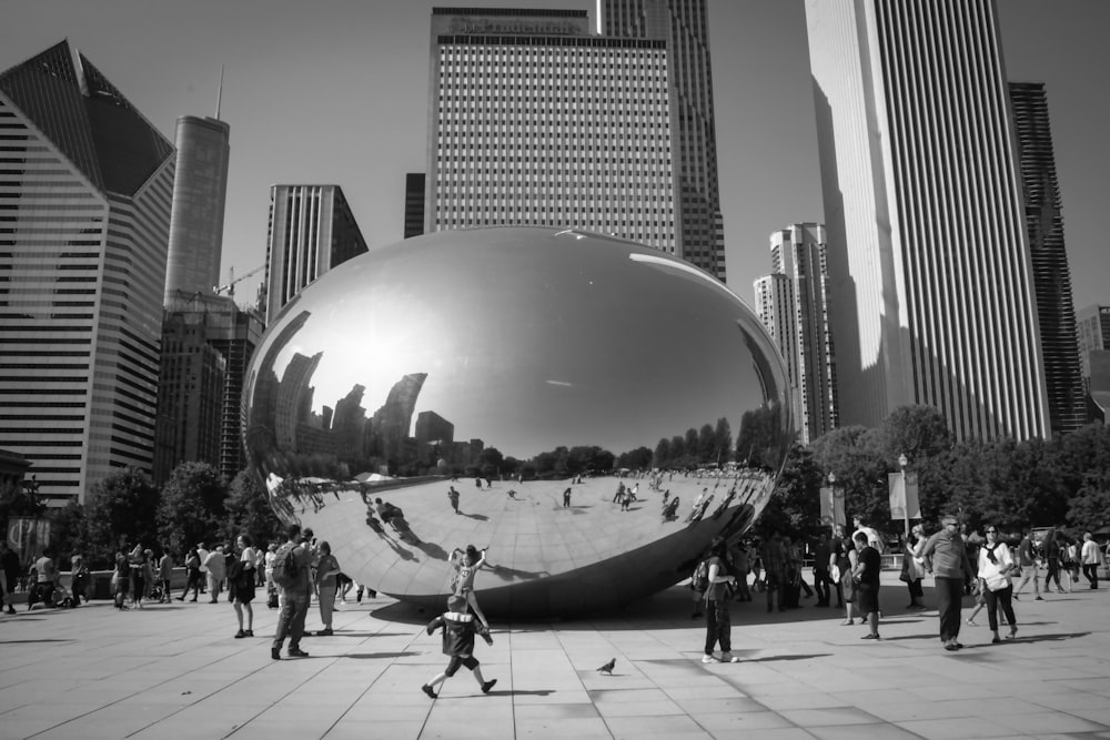 a large metal ball sitting in the middle of a park