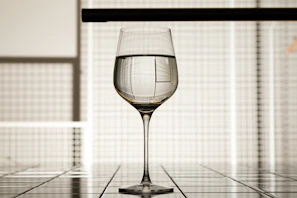 Artisan pouring wine into a crystal glass inside a minimalist tasting room