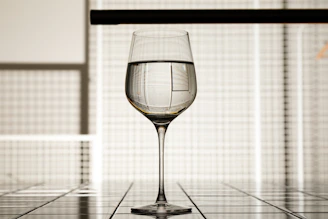 Artisan pouring wine into a crystal glass inside a minimalist tasting room