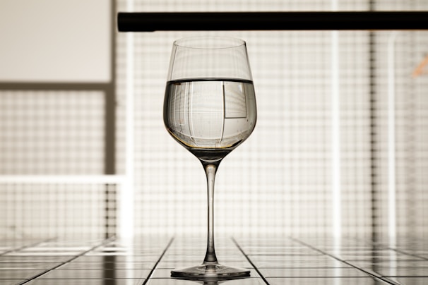 a glass of wine sitting on top of a tiled floor