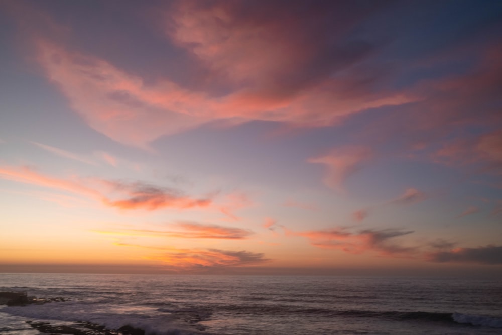 the sun is setting over the ocean with waves