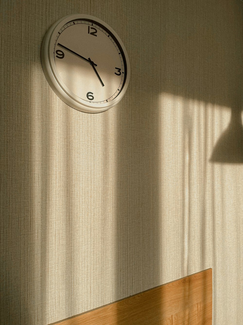 a clock hanging on a wall next to a window
