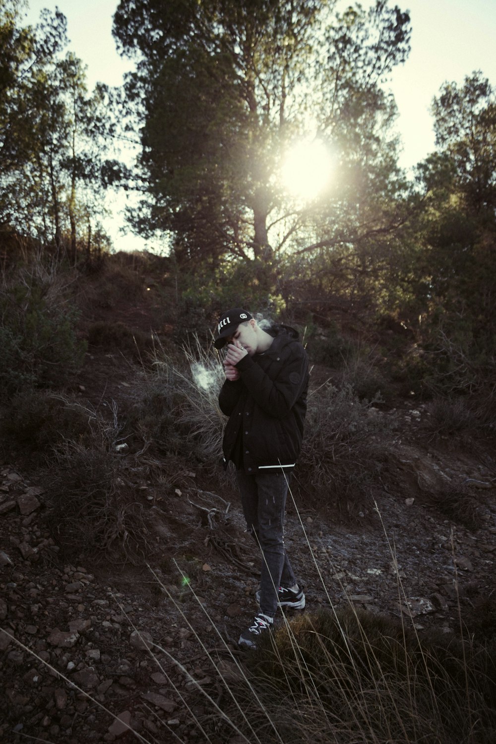 a person standing in a field with trees in the background