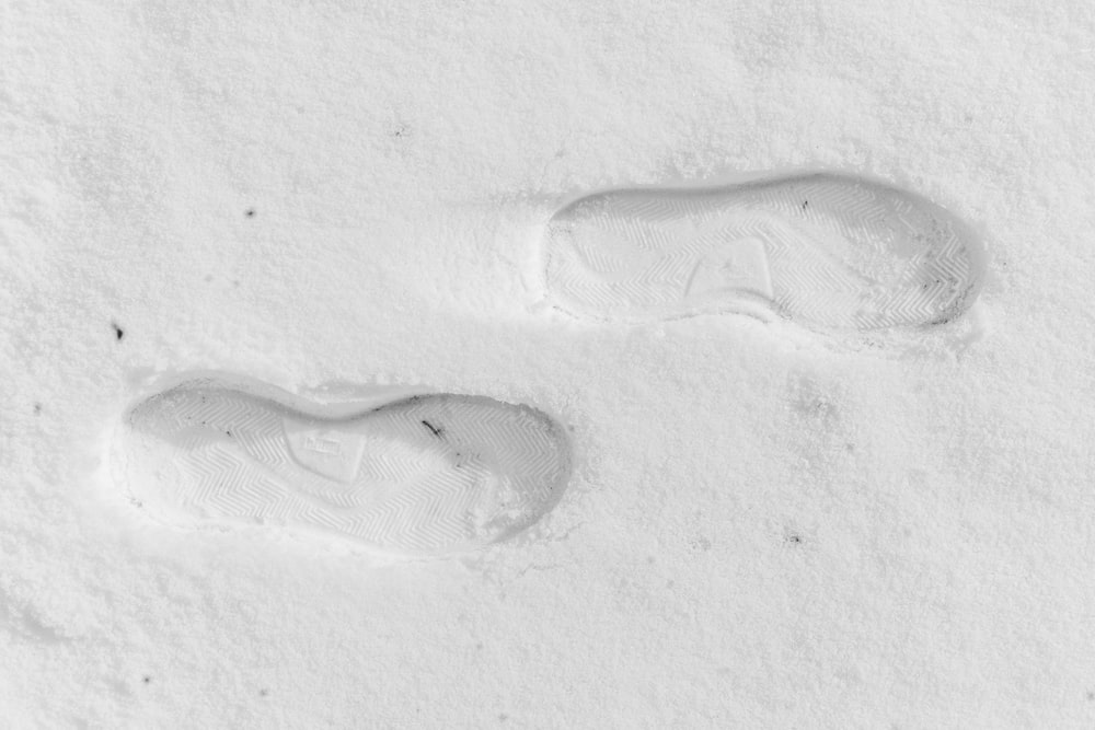 a pair of footprints in the snow on a sunny day