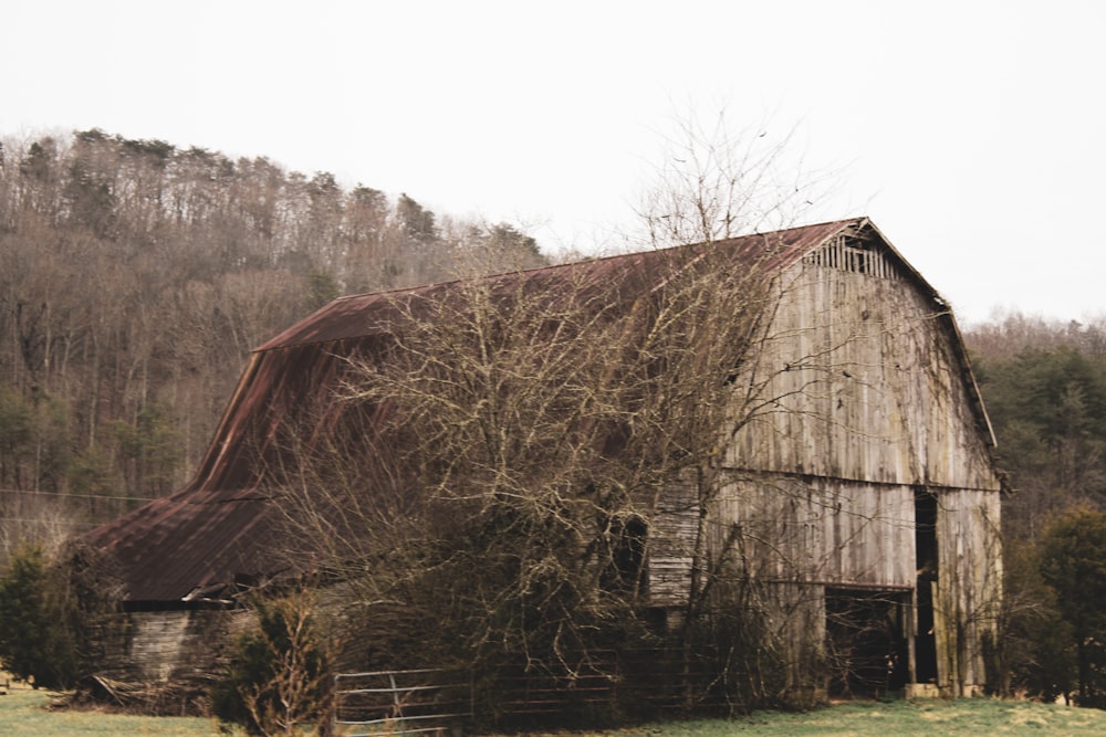 an old barn in the middle of a field
