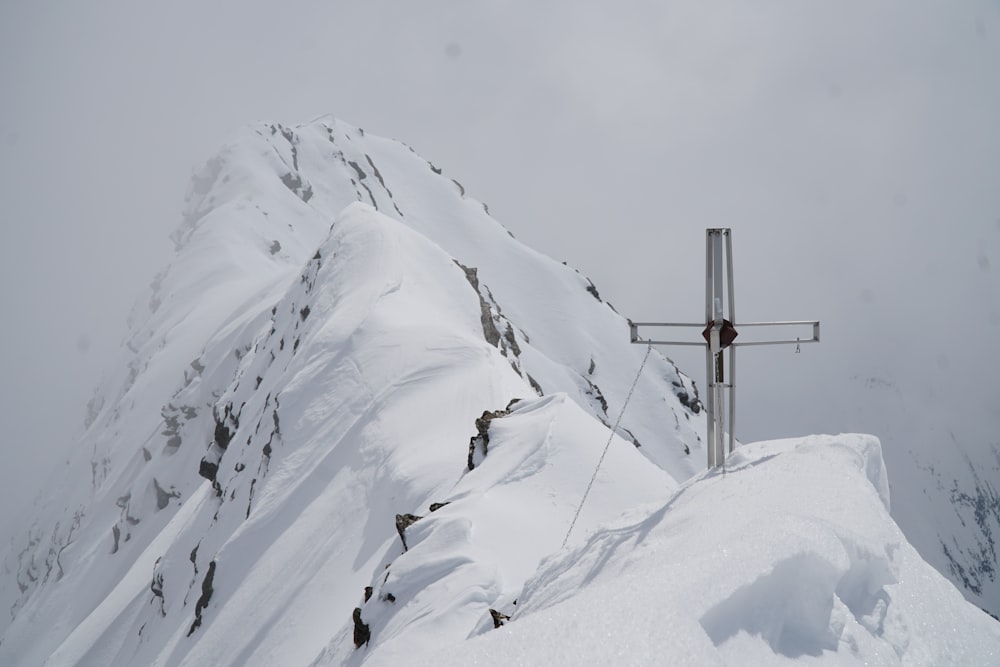 a cross on top of a mountain covered in snow