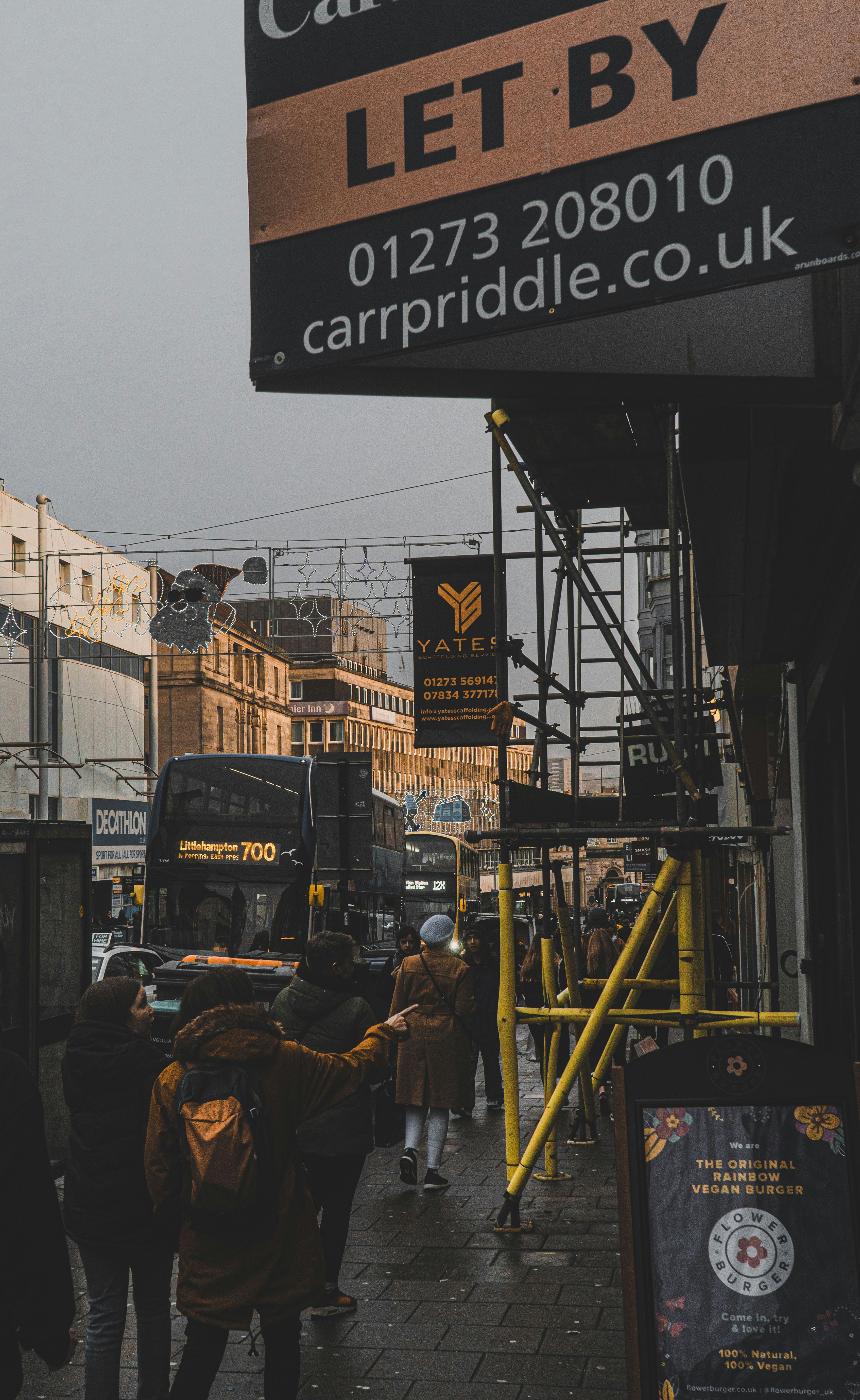 a group of people walking down a street next to a bus