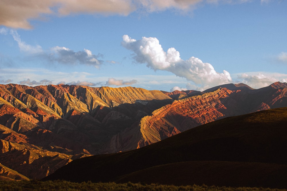 a view of a mountain range with clouds in the sky