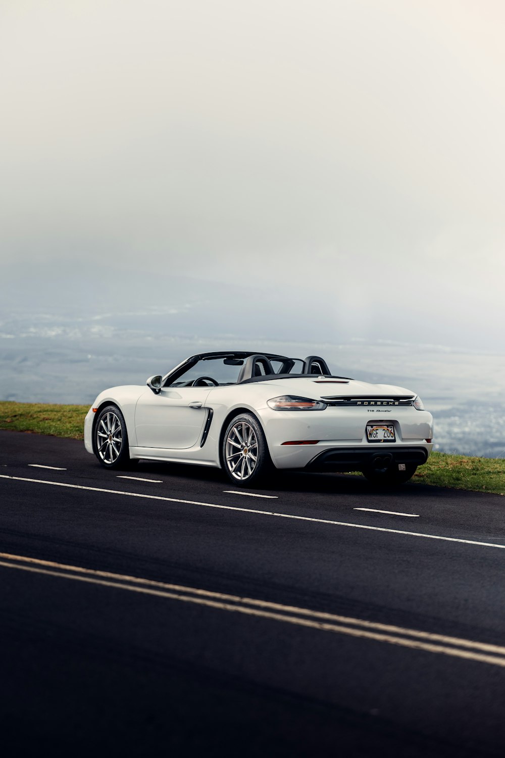 a white sports car driving down a road