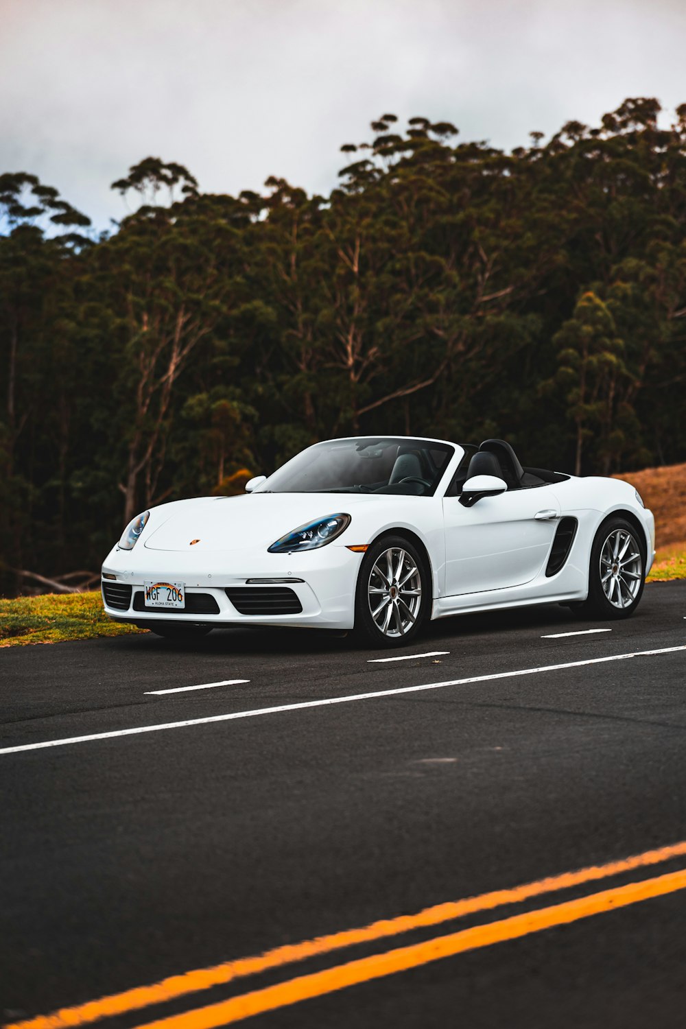 a white sports car driving down the road